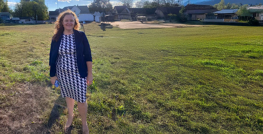 Lindsay M. Webb standing on a cleared lot in a Toledo neighborhood